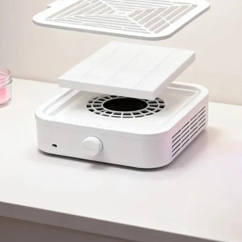 Vue éclatée de l'aspirateur : grille amovible, filtre et turbine, sur une table de manucure
