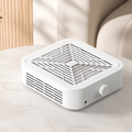 Aspirateur de poussière de manucure 120 W posé sur un guéridon en marbre blanc, dans un salon d'esthétique clair