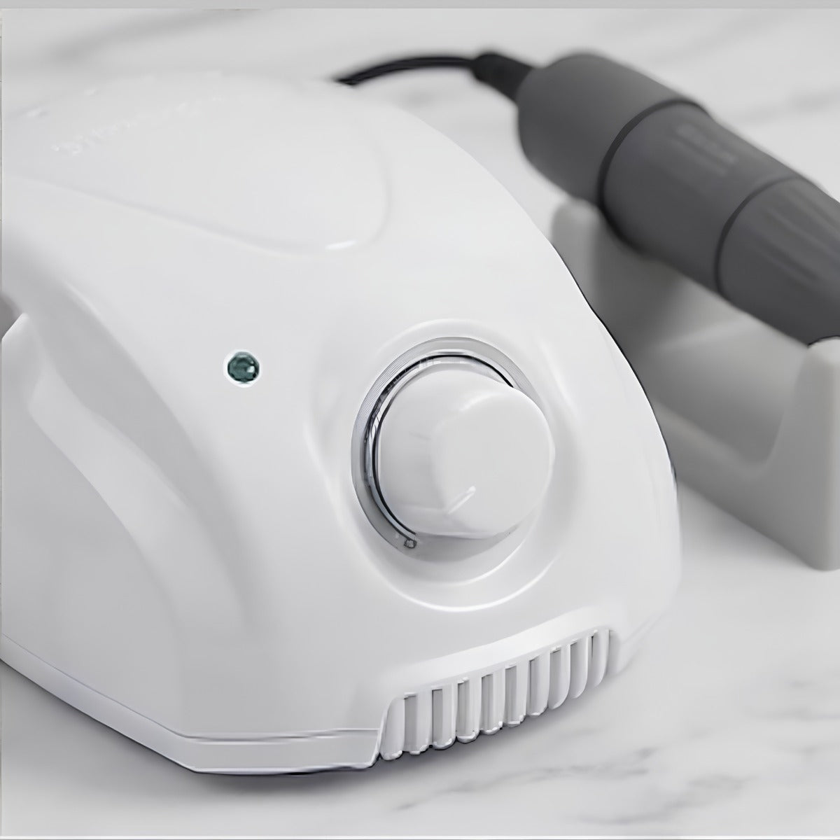 Micromoteur professionnel STRONG 210 blanc avec sa pièce à main posée sur le support